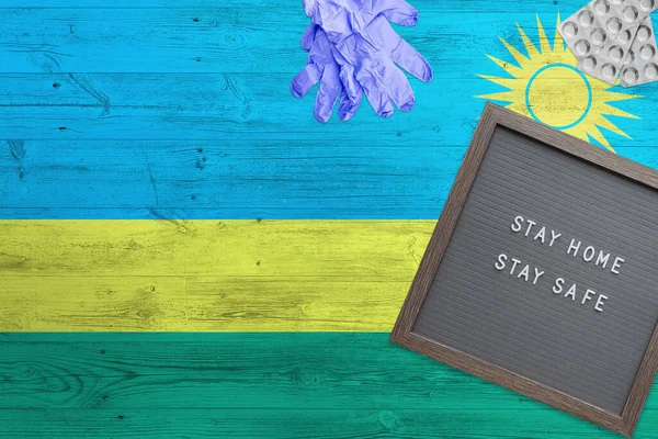 Rwanda Vlag Achtergrond Houten Tafel Stay Home Schrijfbord Chirurgische Handschoenen — Stockfoto