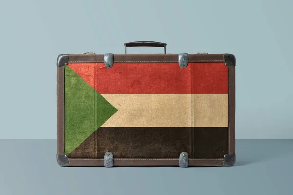 Sudan flag on old vintage leather suitcase with national concept. Retro brown luggage with copy space text.