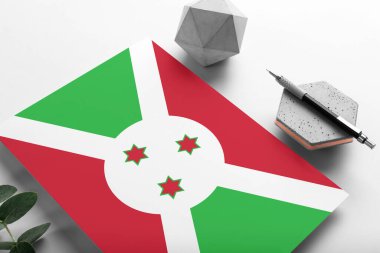 Minimalist kağıt üzerinde Burundi bayrağı. Taşın üzerinde zarif bir kalemle ulusal davetiye mektubu. İletişim konsepti.
