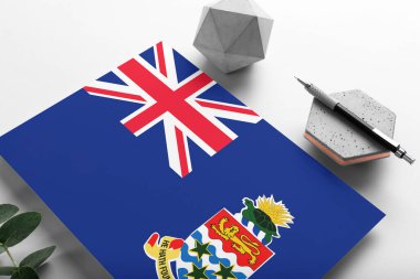 Minimalist kağıt üzerinde Cayman Adaları bayrağı. Taşın üzerinde zarif bir kalemle ulusal davetiye mektubu. İletişim konsepti.