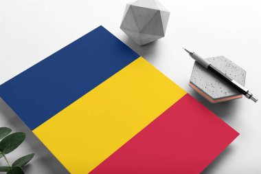 Minimalist kağıt üzerine Chad bayrağı. Taşın üzerinde zarif bir kalemle ulusal davetiye mektubu. İletişim konsepti.
