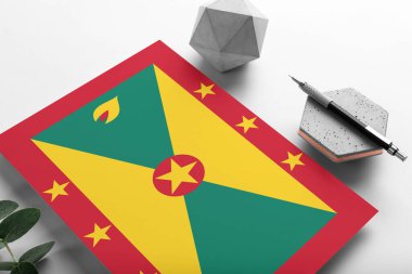 Minimalist kağıt üzerinde Grenada bayrağı. Taşın üzerinde zarif bir kalemle ulusal davetiye mektubu. İletişim konsepti.