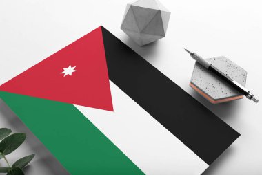 Minimalist kağıt üzerine Jordan bayrağı. Taşın üzerinde zarif bir kalemle ulusal davetiye mektubu. İletişim konsepti.