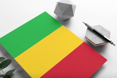 Minimalist kağıt üzerinde Mali bayrağı. Taşın üzerinde zarif bir kalemle ulusal davetiye mektubu. İletişim konsepti.