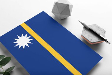 Minimalist kağıt arkaplanda Nauru bayrağı. Taşın üzerinde zarif bir kalemle ulusal davetiye mektubu. İletişim konsepti.