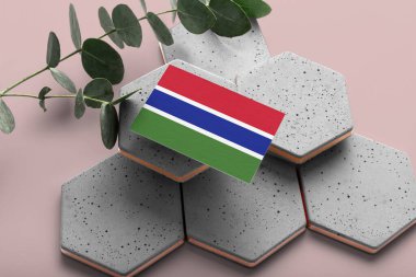 Altıgen taşlarda Gambiya bayrağı. Pembe kopyalama alanı arka planı. Düzlük, üst görünüm asgari ulusal kavram.