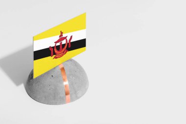 Yuvarlak taşın üzerinde Brunei bayrağı var. Beyaz izole edilmiş arka plan. Yan görünüm asgari ulusal kavram.