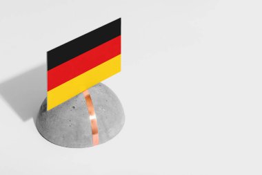 Almanya bayrağı yuvarlak taşın üzerinde. Beyaz izole edilmiş arka plan. Yan görünüm asgari ulusal kavram.