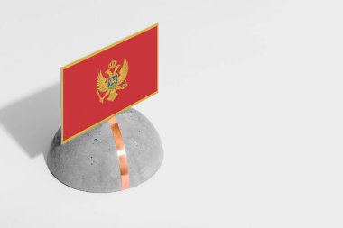 Karadağ bayrağı yuvarlak taşın üzerine dikildi. Beyaz izole edilmiş arka plan. Yan görünüm asgari ulusal kavram.