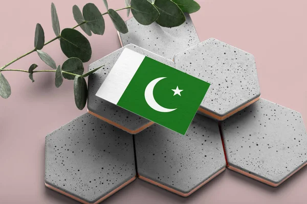 Pakistan flag on hexagon stylish stones. Pink copy space background. Flat lay, top view minimal national concept.