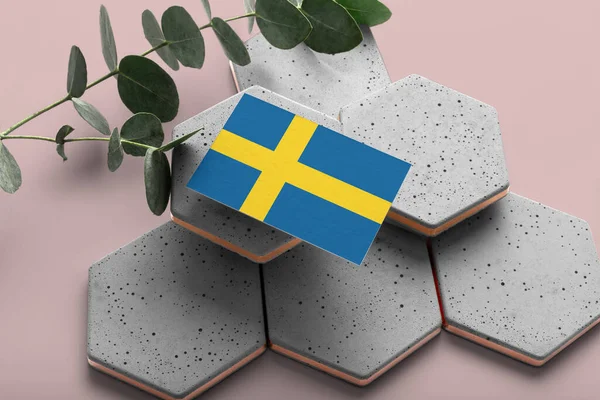 Sweden flag on hexagon stylish stones. Pink copy space background. Flat lay, top view minimal national concept.