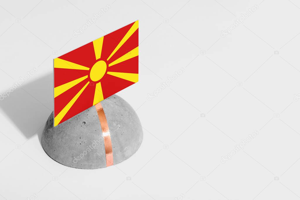 Macedonia flag tagged on rounded stone. White isolated background. Side view minimal national concept.