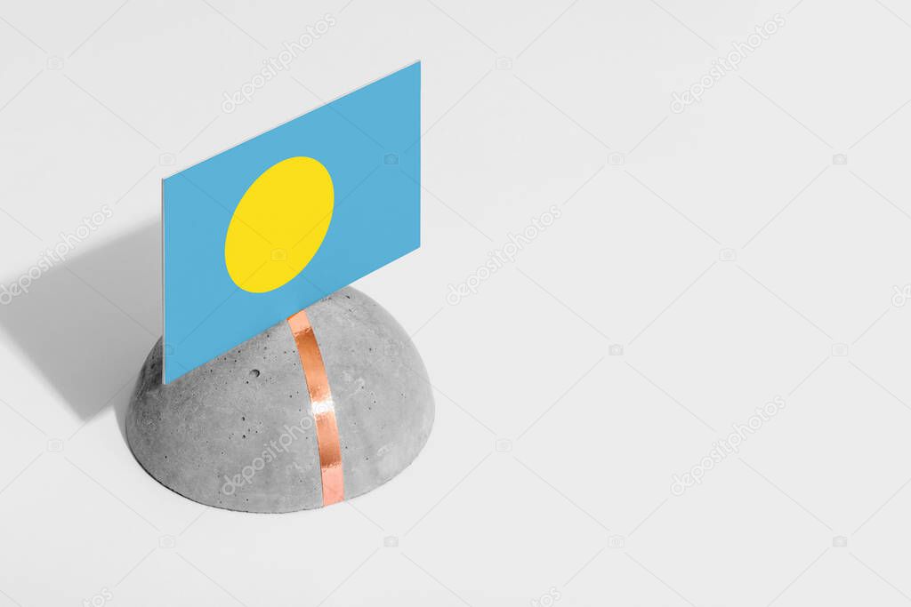 Palau flag tagged on rounded stone. White isolated background. Side view minimal national concept.