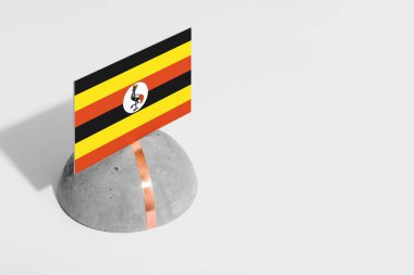 Yuvarlak taşın üzerinde Uganda bayrağı var. Beyaz izole edilmiş arka plan. Yan görünüm asgari ulusal kavram.