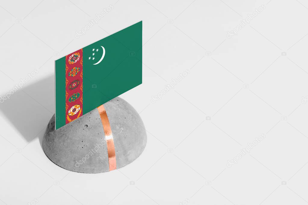 Turkmenistan flag tagged on rounded stone. White isolated background. Side view minimal national concept.