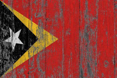 East Timor flag on grunge scratched wooden surface. National vintage background. Old wooden table scratched flag surface. clipart