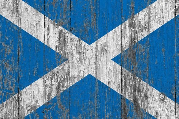 Scotland flag on grunge scratched wooden surface. National vintage background. Old wooden table scratched flag surface.