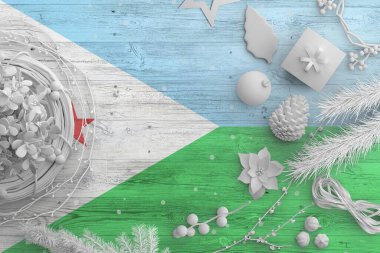 Cibuti bayrağı ahşap masada, üzerinde kar nesneleri olan. Yılbaşı ve yeni yıl arkaplanı, ulusal konsepti beyaz dekor ile kutlamak.