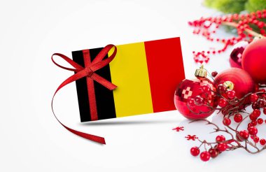 Yeni yıl davetiyesinde Belçika bayrağı ve kırmızı noel süsleri konsepti. Ulusal mutlu yeni yıl kompozisyonu.
