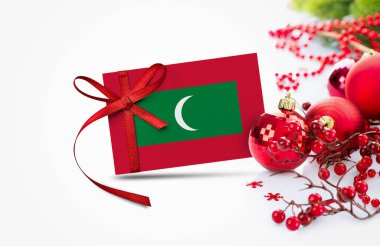 Yeni yıl davetiyesinde kırmızı Noel süsleri konsepti olan Maldivler bayrağı. Ulusal mutlu yeni yıl kompozisyonu.