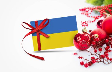 Yeni yıl davetiyesinde Ukrayna bayrağı ve kırmızı noel süsleri konsepti. Ulusal mutlu yeni yıl kompozisyonu.