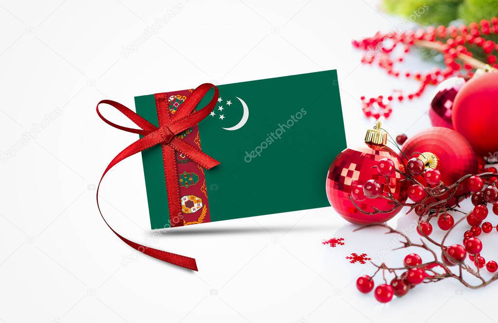Turkmenistan flag on new year invitation card with red christmas ornaments concept. National happy new year composition.