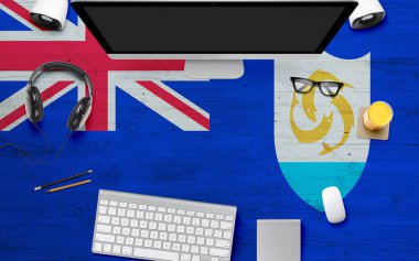 Ulusal ofis masasında kulaklıklı, bilgisayar klavyeli ve fareli Anguilla bayrağı. Kopyalama alanı ile üst görünüm. Düz Yat Yat.