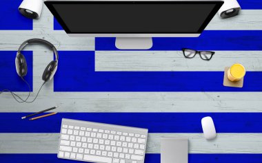 Yunanistan, ulusal ofis masasında kulaklık, bilgisayar klavyesi ve fareyle bayrak arkaplanı oluşturdu. Kopya alanlı üst görünüm. Düz Yat Yat.