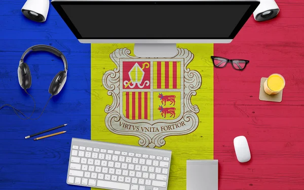 Andorra flag background with headphone,computer keyboard and mouse on national office desk table.Top view with copy space.Flat Lay.