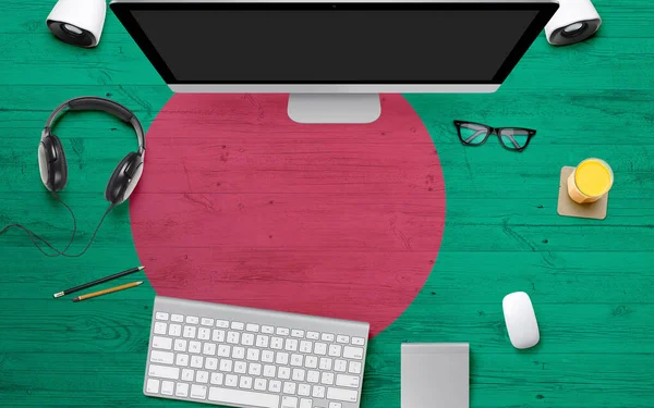 Bangladesh flag background with headphone,computer keyboard and mouse on national office desk table.Top view with copy space.Flat Lay.