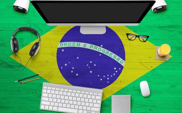 Brazil flag background with headphone,computer keyboard and mouse on national office desk table.Top view with copy space.Flat Lay.