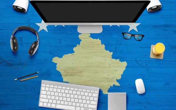 Kosovo flag background with headphone,computer keyboard and mouse on national office desk table.Top view with copy space.Flat Lay.