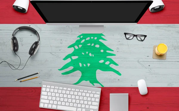 Lebanon flag background with headphone,computer keyboard and mouse on national office desk table.Top view with copy space.Flat Lay.