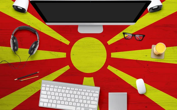 Macedonia flag background with headphone,computer keyboard and mouse on national office desk table.Top view with copy space.Flat Lay.