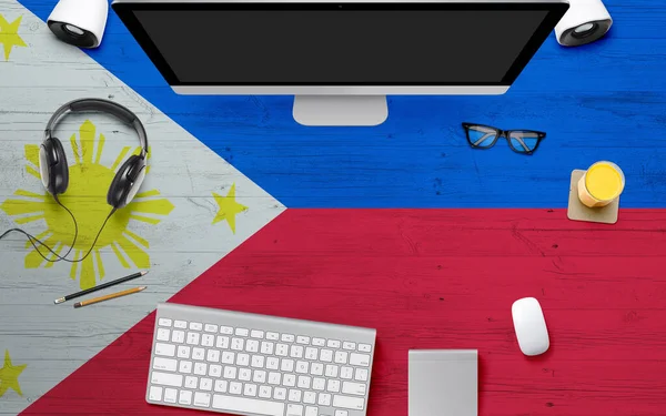 Philippines flag background with headphone,computer keyboard and mouse on national office desk table.Top view with copy space.Flat Lay.