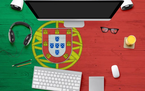 Portugal flag background with headphone,computer keyboard and mouse on national office desk table.Top view with copy space.Flat Lay.