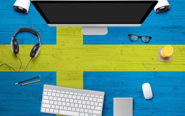 Sweden flag background with headphone,computer keyboard and mouse on national office desk table.Top view with copy space.Flat Lay.