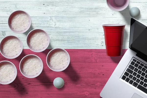 Poland flag concept with plastic beer pong cups and laptop on national wooden table, top view. Beer Pong game.