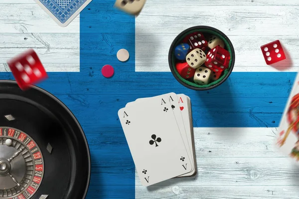 Finland casino theme. Aces in poker game, cards and chips on red table with national flag background. Gambling and betting.