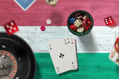 Macar kumarhanesi teması. Pokerdeki aslar, kırmızı masada ulusal bayrak geçmişi olan kartlar ve çipler. Kumar ve bahis.
