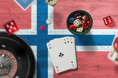 Norveç kumarhanesi teması. Pokerdeki aslar, kırmızı masada ulusal bayrak geçmişi olan kartlar ve çipler. Kumar ve bahis.