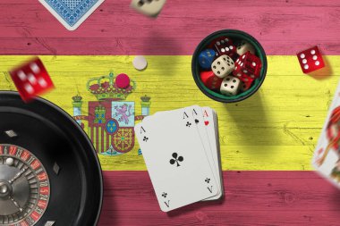 İspanya kumarhanesi teması. Pokerdeki aslar, kırmızı masada ulusal bayrak geçmişi olan kartlar ve çipler. Kumar ve bahis.
