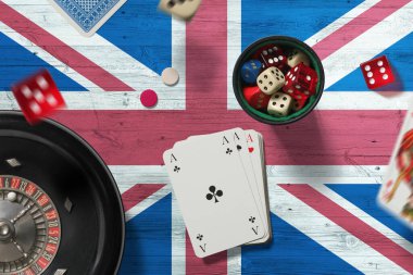Birleşik Krallık kumarhane teması. Pokerdeki aslar, kırmızı masada ulusal bayrak geçmişi olan kartlar ve çipler. Kumar ve bahis.