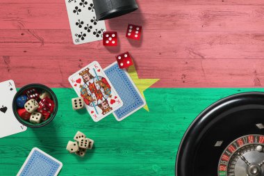 Burkina Faso kumarhane teması. Pokerdeki aslar, kırmızı masada ulusal tahta bayraklı kartlar ve fişler. Kumar ve bahis.