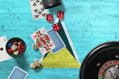 Saint Lucia Kumarhanesi teması. Pokerdeki aslar, kırmızı masada ulusal tahta bayraklı kartlar ve fişler. Kumar ve bahis.
