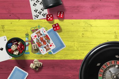 İspanya kumarhanesi teması. Pokerdeki aslar, kırmızı masada ulusal tahta bayraklı kartlar ve fişler. Kumar ve bahis.