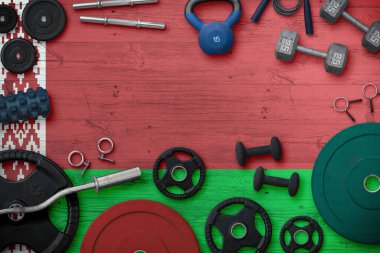 Belarus spor ve spor konsepti. Ulusal arkaplanda demir çubuk bulunan ağır ağırlık plakalarının üst görünümü.