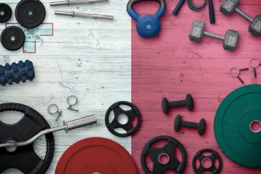 Malta spor ve spor konsepti. Ulusal arkaplanda demir çubuk bulunan ağır ağırlık plakalarının üst görünümü.