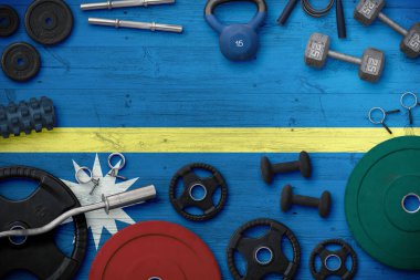 Nauru spor ve spor konsepti. Ulusal arkaplanda demir çubuk bulunan ağır ağırlık plakalarının üst görünümü.