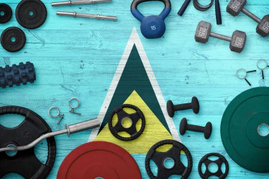 Saint Lucia Spor ve Spor Konsepti. Ulusal arkaplanda demir çubuk bulunan ağır ağırlık plakalarının üst görünümü.